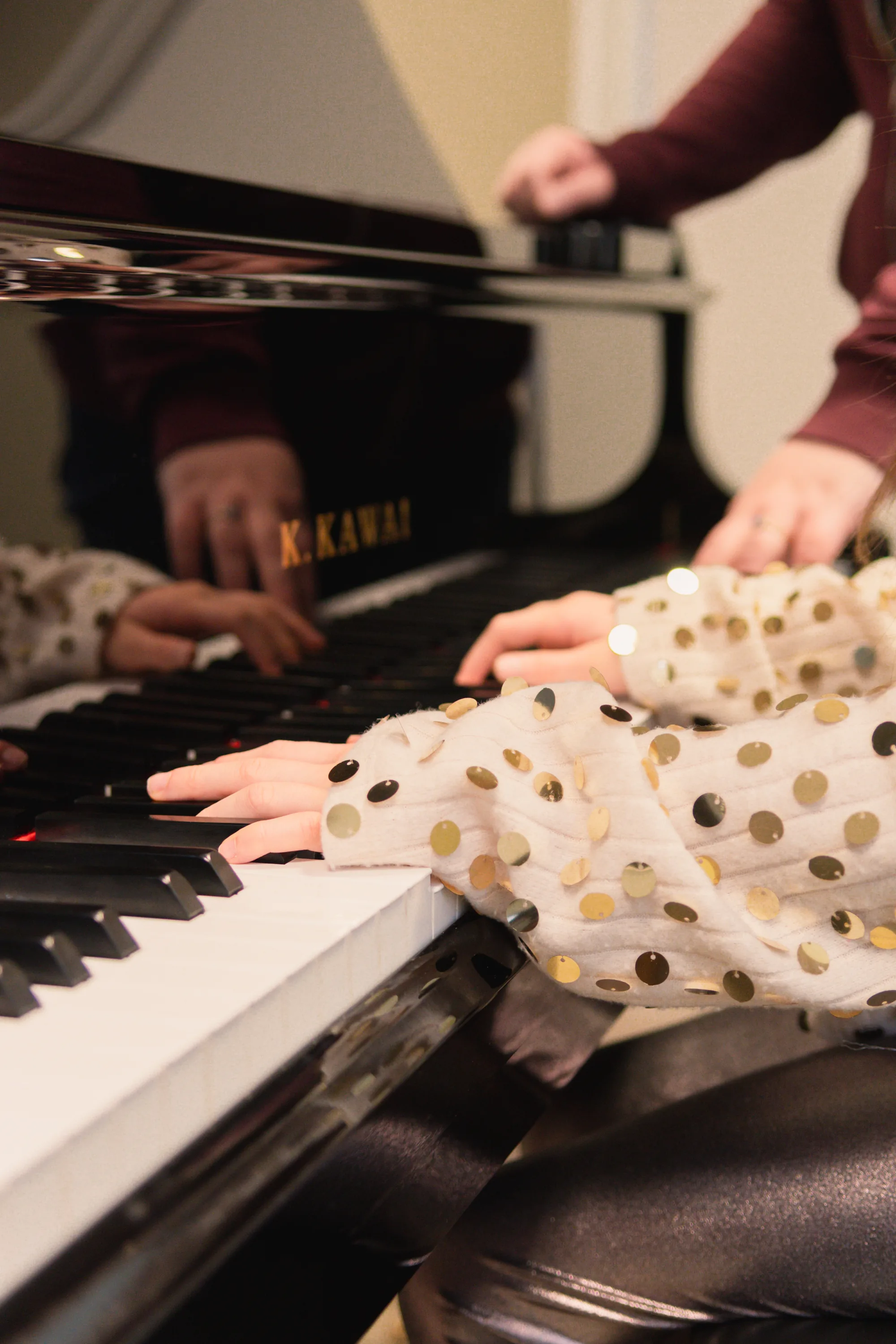 Kinder und Lehrkraft spielen gemeinsam Klavier